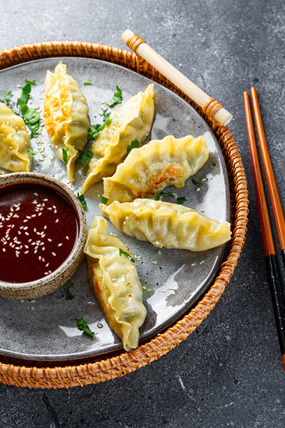 灰色背景上的亚洲饺子与辣酱的竖版照片图片下载