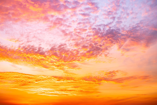 美丽奢华的柔和渐变橙金色云彩和阳光映照在蓝天上，完美适合作为背景，拍摄于傍晚黄昏，大尺寸高清风景照片图片下载