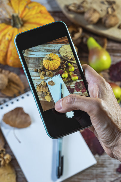 用手机拍摄秋季笔记本的照片图片下载