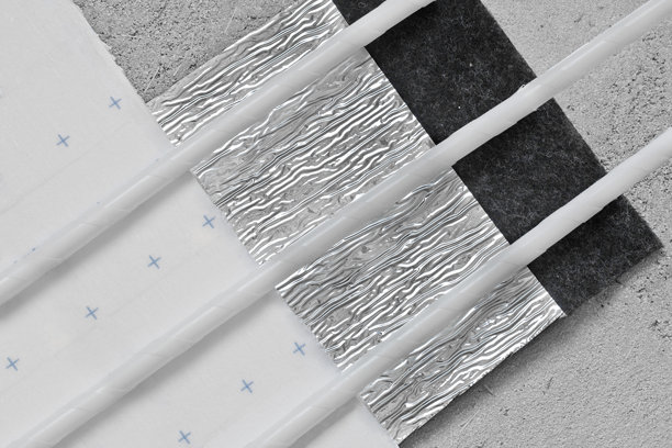 带有白色管道的地暖系统安装，使用魔术贴固定在绝缘垫上 - 现代辐射地暖管道在施工表面上以环形排列，实现节能加热。图片下载