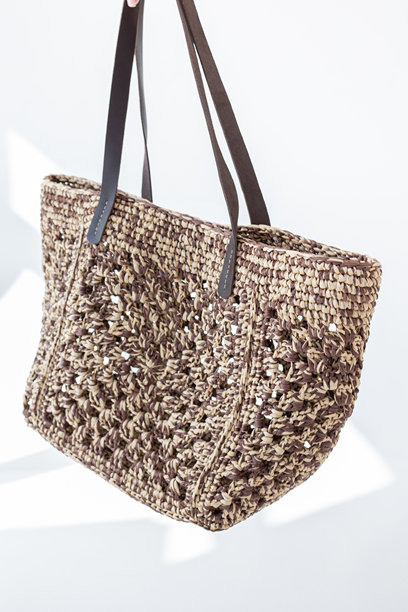 女性手持时尚编织包。时尚与奢华配饰。竖版照片。图片下载