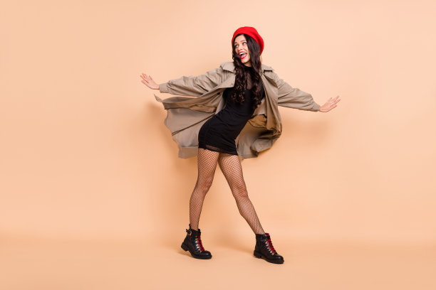 迷人的女孩在淡米色背景上跳舞的全身肖像照片图片下载