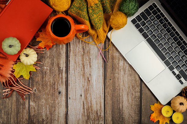 秋季主题的工作空间概念。俯视照片展示时尚舒适的格子布、咖啡杯、记事本和白色背景上的秋叶，带有促销区域。图片下载