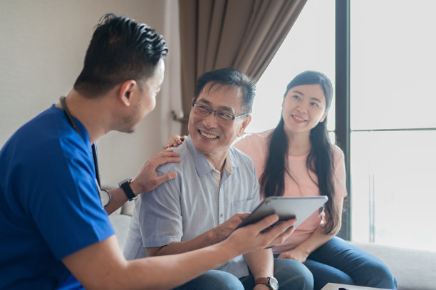 家庭护理医疗专业人员使用数字平板向患者及其家属展示健康报告的库存照片图片下载