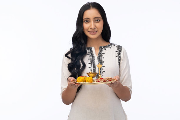 在白色背景下，漂亮的女性手持普贾托利（Pooja thali）庆祝排灯节的照片图片下载