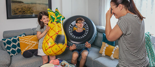 快乐的家庭在为度假打包行李，母亲在出发前拍摄美好回忆的照片。图片下载