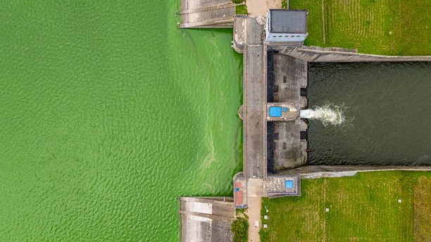 米耶特库夫水库大坝的航拍照片，展示了水流通过闸门的情景、绿色的湖面以及大坝的技术区域。图片下载