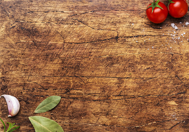 食物和烹饪背景，木质切菜板上的香料和草药，俯视图。玫瑰和黑胡椒，迷迭香，罗勒，番茄及其他食材。图片下载