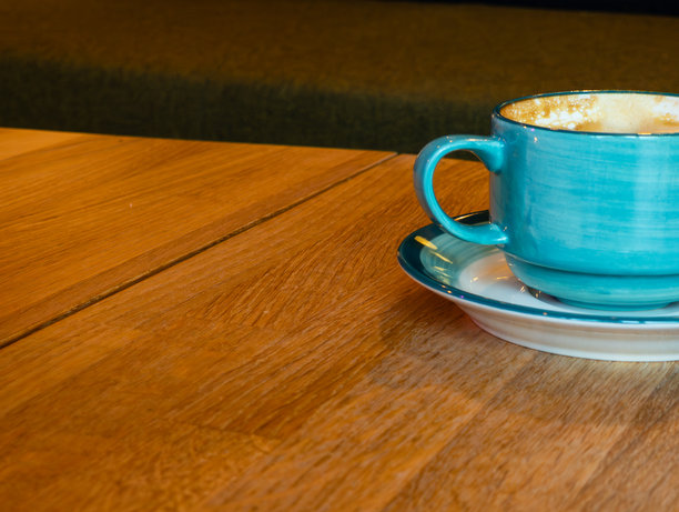 蓝色咖啡杯部分可见，放在木桌上。热饮，咖啡。杯子位于照片的右侧。图片下载