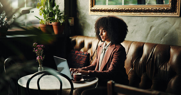 创意女性在咖啡馆使用笔记本电脑进行数字营销，远程工作和在线工作。自由职业者，社交媒体专家或拥有技术的人，专注于品牌形象、研究或咖啡店。图片下载