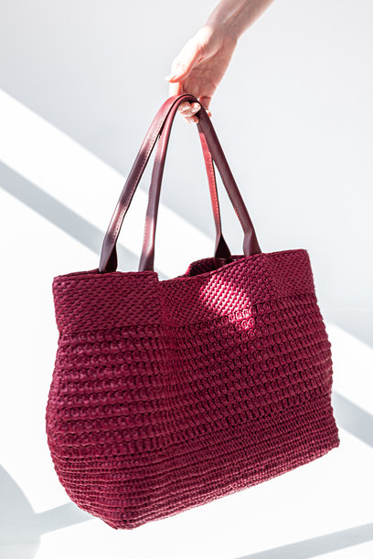 女性手持时尚红色编织包。时尚与奢华配饰。竖版照片。图片下载