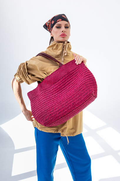 美丽的女性手持时尚的红色编织包。时尚与奢华配饰。竖版照片。图片下载