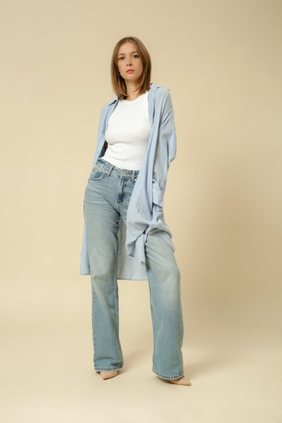 一系列女性穿着经典基础服装的工作室照片 - 蓝色牛仔裤、白色背心和蓝色棉质长款宽松衬衫。图片下载