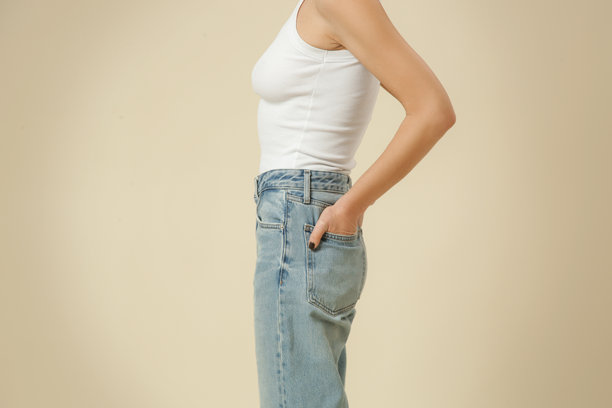 一系列工作室照片，展示穿着经典基础服装的女性 - 蓝色牛仔裤和白色背心。图片下载