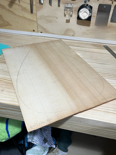 精心准备的琵琶吉他的音板放在木工工作台上，标志着弦乐器制作这一细致工艺的初步步骤。图片下载