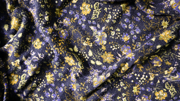 印刷面料制成的照片背景。不同地方有混乱的褶皱。由不同的花朵和叶子组成的装饰。图片下载