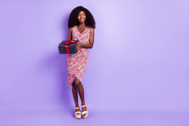 好奇女孩在派对上手持礼物盒，背景为柔和的紫色，留有空白空间的全身照片。图片下载