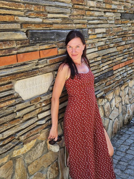 时尚模特在墙前摆姿势。年轻女性穿着裙子的照片。图片下载