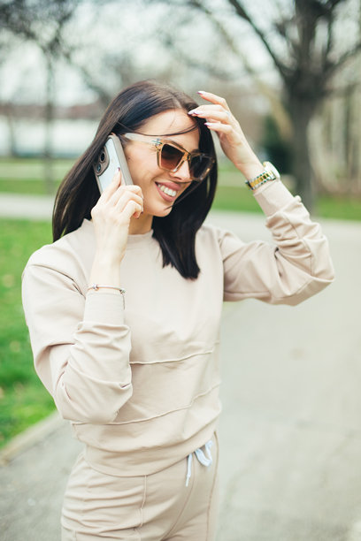 美丽的女人在公园里打电话的照片图片下载