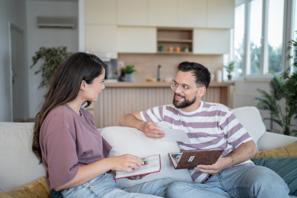 一对情侣在家中翻看相册里的旧照片图片下载