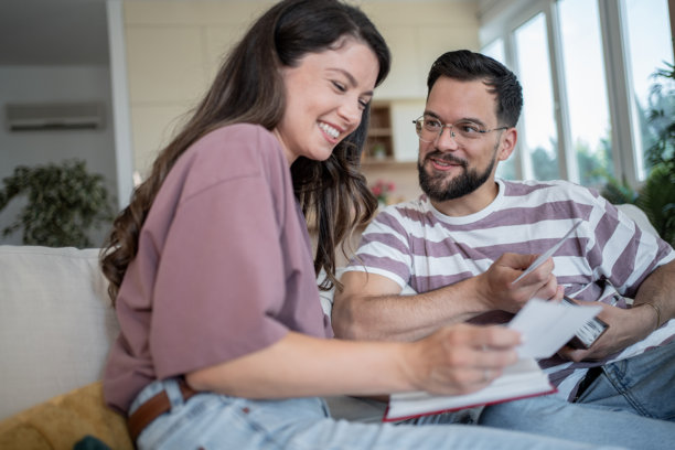 快乐的情侣微笑着翻看相册中的旧照片图片下载