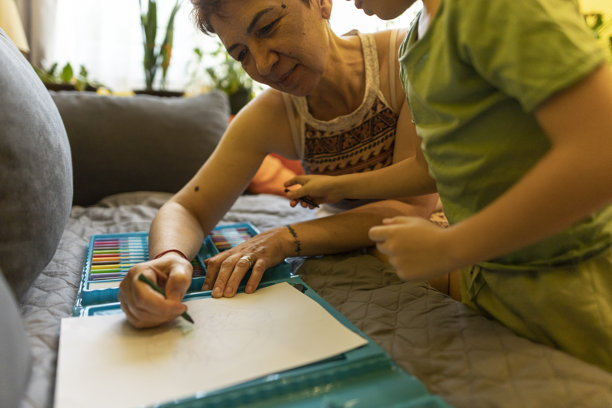 特写照片：男孩和祖母一起享受绘画时光图片下载