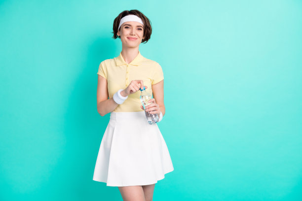 年轻美丽微笑的女网球运动员在青色背景下喝水休息的照片图片下载