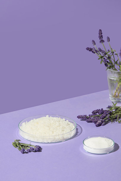 垂直照片展示了薰衣草花朵和圆形浴盐碗，背景为紫色，适合自然水疗和身体护理主题的设计。图片下载