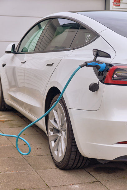 白色特斯拉电动汽车在瑞典的家用车道上充电图片下载