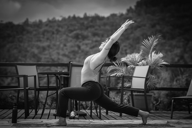户外甲板上年轻女性高位弓步瑜伽姿势的黑白照片图片下载