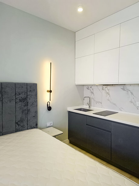 现代简约风格的酒店房间室内。床和厨房区域。竖版照片。图片下载