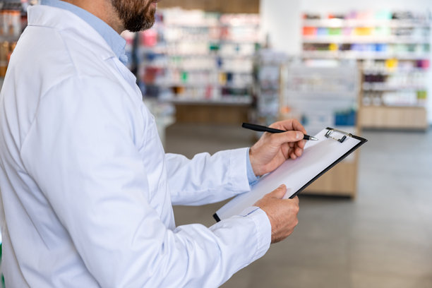 穿着实验室外套的男子在做笔记的特写照片图片下载