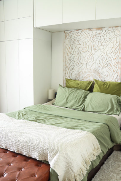 现代卧室的图片，配有白色内置衣柜、双人床、奶油色和橄榄绿色的被子、绗缝床单和舒适的地毯。图片下载