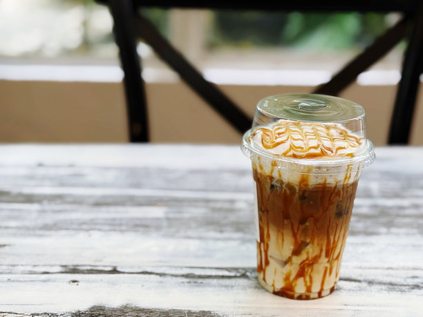 木桌上的塑料杯冰咖啡，库存照片图片下载