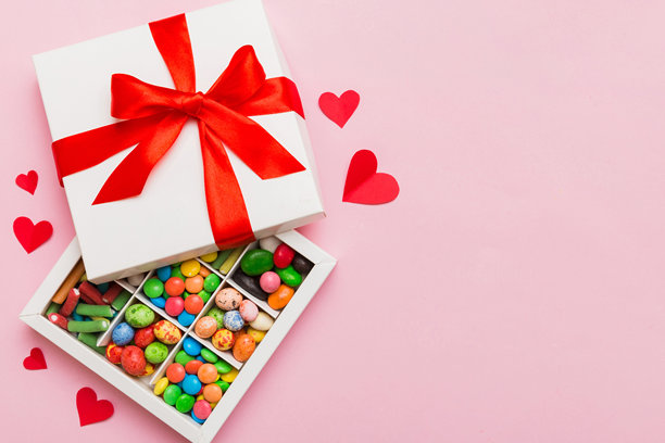 情人节构图：甜蜜的糖果，带有蝴蝶结的礼品盒和红色毛毡心，照片模板，背景。俯视图，留白空间。图片下载