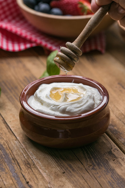 奶油酸奶淋上金色蜂蜜。健康自然的早餐选择，完美适合清淡饮食和营养均衡。图片下载