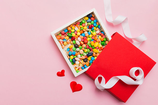 情人节构图：甜蜜的糖果，带有蝴蝶结的礼品盒和红色毛毡心形，照片模板，背景。俯视图，留白空间。图片下载