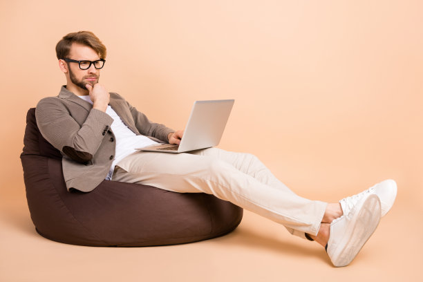 年轻有吸引力的思考型商人在米色背景上思考新项目的全身照片图片下载