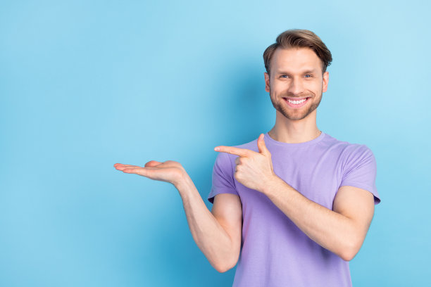 微笑的男士手持空白空间的照片肖像，背景为柔和的蓝色。图片下载
