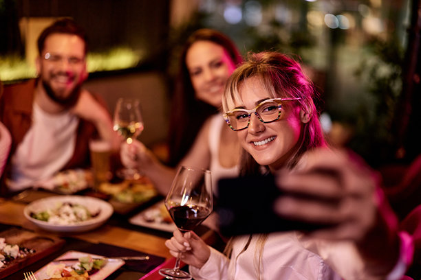朋友们一起享用晚餐和饮品，通过照片记录美好回忆图片下载