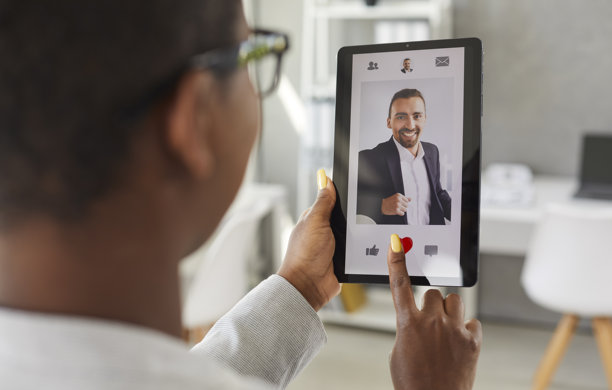 女人使用平板电脑，在在线约会应用或网站上给一位男性的照片点赞图片下载