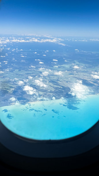 从飞机窗外看到的蓝天、美丽的云朵和清澈的海洋 高清海洋照片图片下载