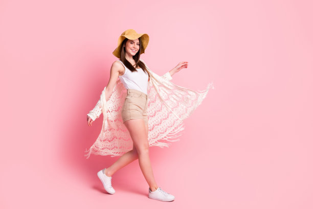 可爱的满意女士在粉色背景下享受假期，面向镜头的全身侧面照片图片下载
