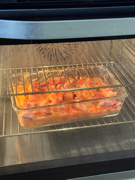 热烤箱内的玻璃烤盘鸡肉炖菜，家常烤盘在照明风扇的架子上烹饪，前景聚焦。图片下载