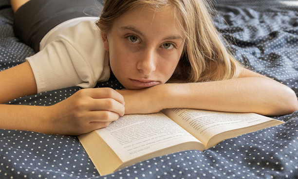 11岁女孩在家中阅读书籍的特写照片，捕捉了一个适合教育、休闲和儿童学习主题的温馨生活瞬间。图片下载
