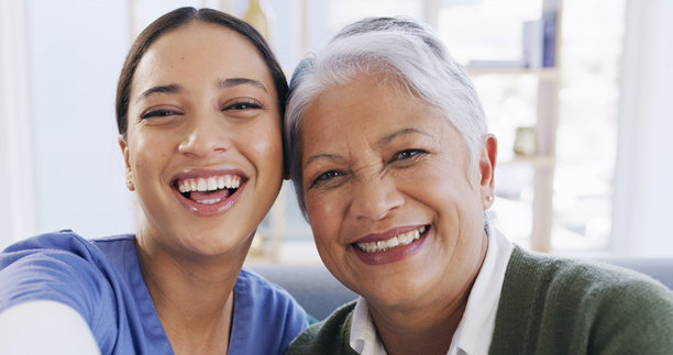 护理人员与养老院中的老年女性的肖像，自拍或社交媒体或网站的个人资料照片。医疗保健、护士与老年患者的亲密关系，摄影视角，记录在家中的快乐回忆。图片下载