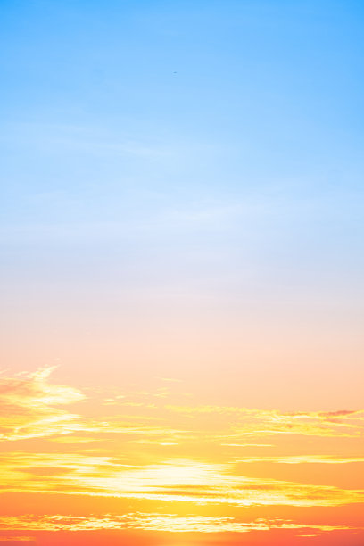 美丽奢华的柔和渐变橙金色云彩和阳光映衬在蓝天上，完美适合作为背景，拍摄于傍晚黄昏，大尺寸高清风景照片，竖版。图片下载