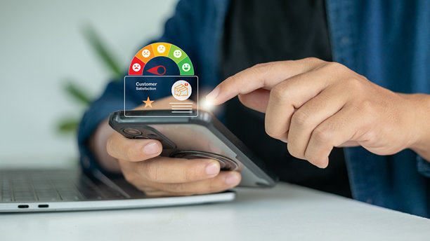 一只手拿着智能手机，屏幕上显示着一个全息客户满意度仪表，显示低评分和差评。负面评价、不满、在线购物反馈和服务质量的概念。图片下载