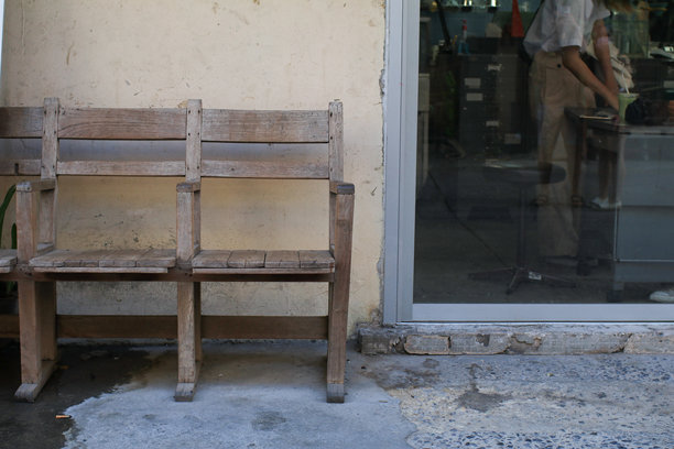 餐厅前一把木椅靠在破旧的墙壁上。复古风格的磨损家具，营造出一种电影般的废弃美感。图片下载