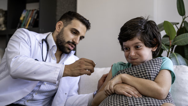 一个害怕打针的孩子正在接种疫苗。这个害怕针头的孩子闭上眼睛，接种时非常害怕。图片下载